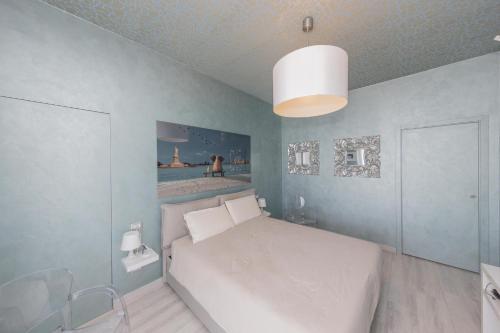 韦尔巴尼亚La Terrazza sul Lago的卧室配有白色的床和蓝色的墙壁