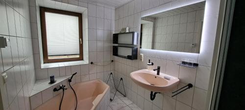 布赖滕布伦Zur alten Schmiede - Breitenbrunn/Erzgebirge的浴室配有盥洗盆、镜子和浴缸