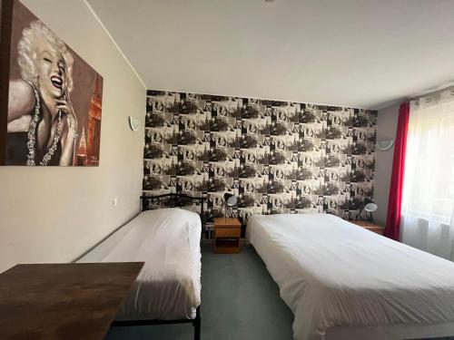敦刻尔克Hôtel Les Jardins Dunkerque centre的一间卧室设有两张床,墙上挂着一幅画