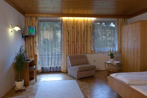 穆尔河畔布鲁克Gasthof Pichler的一间卧室配有一张床、一把椅子和窗户。