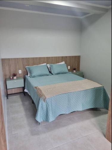 本图贡萨尔维斯LOFT DONA MARIA的一间卧室配有一张带蓝色枕头的大床