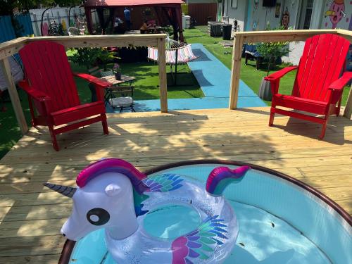 迈阿密Art Graffiti的两把椅子旁边的一个游泳池里的塑料玩具大象