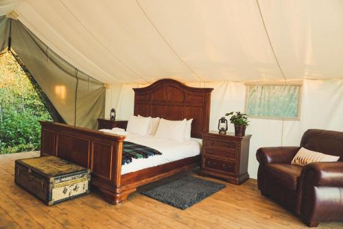 HillierFronterra Farm- Luxury Camp Experiences的一间卧室配有一张床,一张沙发位于帐篷内