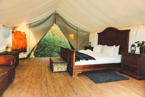 HillierFronterra Farm- Luxury Camp Experiences的一间卧室配有一个带一张床和一张沙发的帐篷