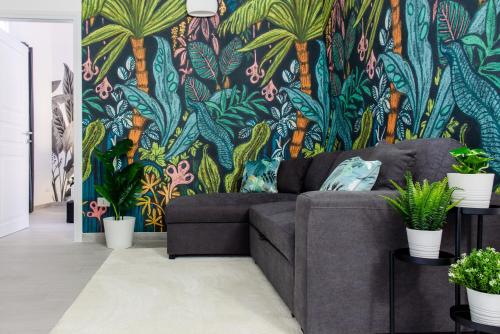 加利波利Tropical - Boutique Apartment的带沙发和热带壁纸的客厅