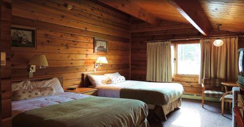 贾斯珀亚斯普尔别墅酒店的小木屋内一间卧室,配有两张床