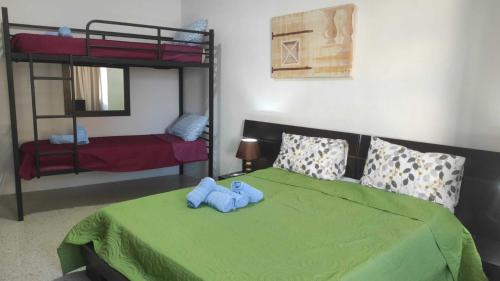圣朱利安斯San Salvatore Home的一间卧室配有一张绿床,上面有蓝色泰迪熊