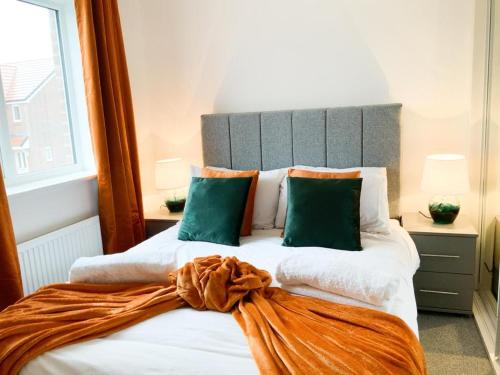 安德沃Antley House的一间卧室配有一张带绿色枕头的大床