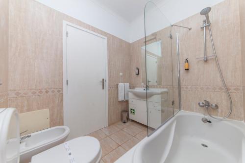拉戈斯Atalaia Sol Aparthotel - tennis & heated pool in winter的带浴缸、卫生间和盥洗盆的浴室