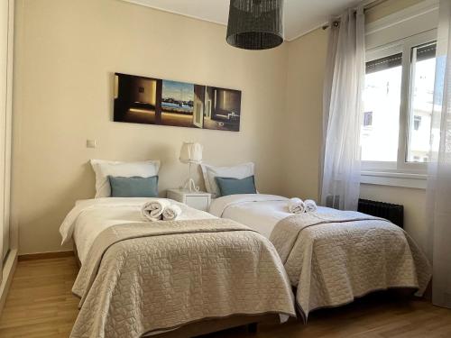 雅典Stunning Penthouse Combo near Glyfada - free Parking的一间卧室配有两张带毯子的床