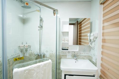 下龙湾Thành Đô Hotel Hạ Long的一间带水槽和玻璃淋浴的浴室