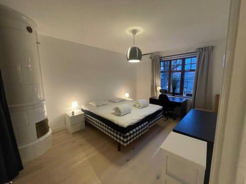 斯德哥尔摩Apartment Garbo的一间卧室配有一张床、一张书桌和一个窗户。