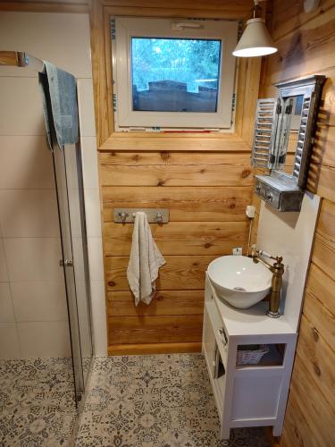 Domek z bala na Podlasiu z balią ogrodową的一间带水槽的浴室和墙上的电视