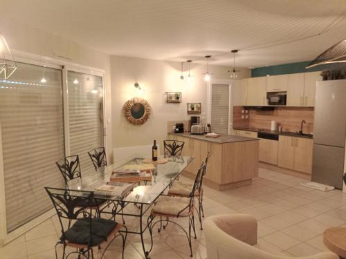 拉卡诺奥肯Villa du Golf Eden Parc的厨房以及带桌椅的用餐室。
