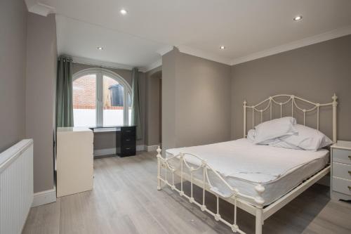 SurbitonRiverside Central Kingston Flat 1B的卧室配有白色的床和窗户。
