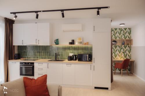 克卢日-纳波卡ZEN Garden Apartments的一间厨房,内设白色橱柜和沙发