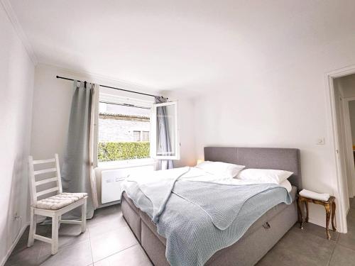 阿斯科纳Casa Via Saleggi 10的一间卧室设有一张床、一个窗口和一把椅子