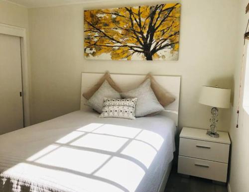 洛杉矶2 Bd Beverly Hills Guest House的卧室配有一张床,墙上挂有绘画作品