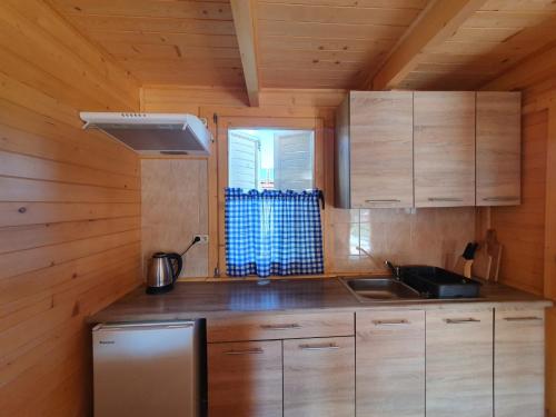 尤斯托尼莫斯基Hals domki letniskowe的小屋内的厨房设有木制橱柜和水槽