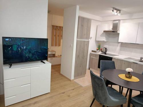 扎达尔Apartment Longin的厨房以及带桌子和电视的用餐室。