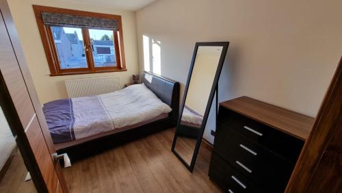 爱丁堡Self-catering extended family home的一间小卧室,配有一张床和镜子