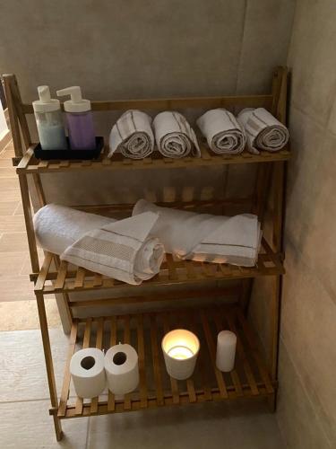 马达巴MiaDabia Supreme的浴室内带毛巾和洗浴用品的架子