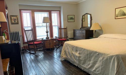 LakesideLakeside Inn的卧室配有一张床、一张桌子和椅子