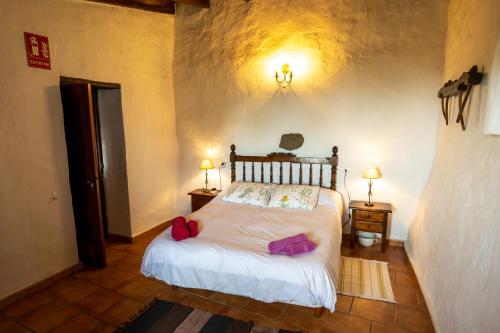El Pinar del HierroCasa rural La Jarita的一间卧室,配有一张带两个袋子的床