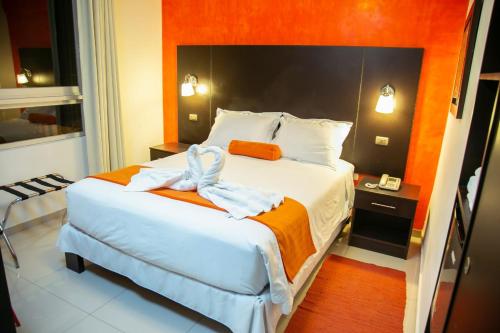 特鲁希略Hotel Killari Trujillo的一间卧室配有一张带橙色墙壁的大床