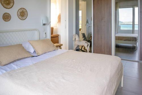 Saint BarthelemyMaison Palmier Blanc的卧室配有白色床,享有海景