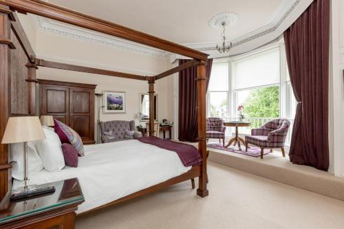 斯特灵Victoria Square & The Orangery的一间卧室设有一张天蓬床和一个阳台