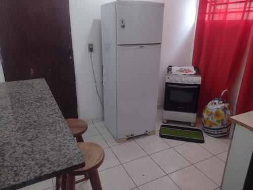 瓜拉廷格塔Apartamento Encantador的厨房配有白色冰箱和炉灶。