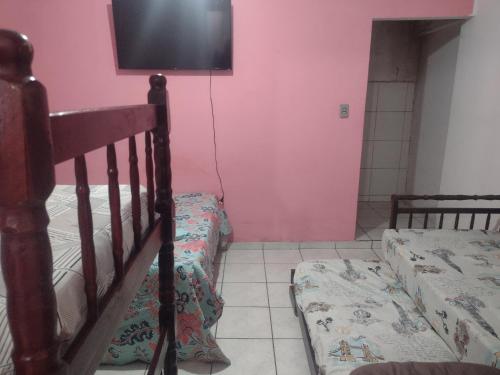 瓜拉廷格塔Apartamento Encantador的一间卧室配有两张双层床和一台平面电视
