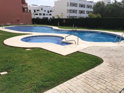 维拉Atico con piscina privada y vistas al mar的一座带草木雕的游泳池