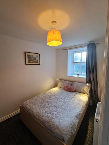 阿尔弗斯顿3 bedroom apartment in Ulverston Cumbria的一间小卧室,配有床和窗户