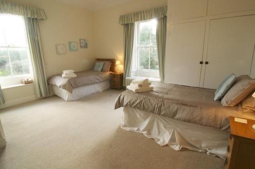 北查尔顿岩沼屋住宿加早餐旅馆的一间卧室设有两张床和两个窗户。