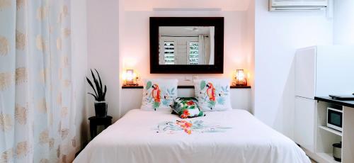 SarraméaEVASION Bungalow Tropical Spa的一间卧室配有一张带白色床单和镜子的床