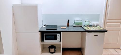 SarraméaEVASION Bungalow Tropical Spa的带微波炉的黑色柜台的小厨房