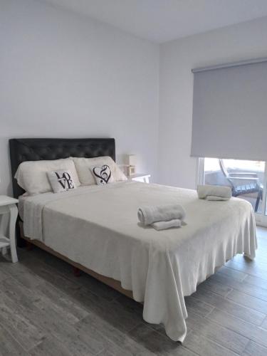 蒂格雷MIRADORES DEL BOULEVAR的白色卧室配有一张大床和毛巾