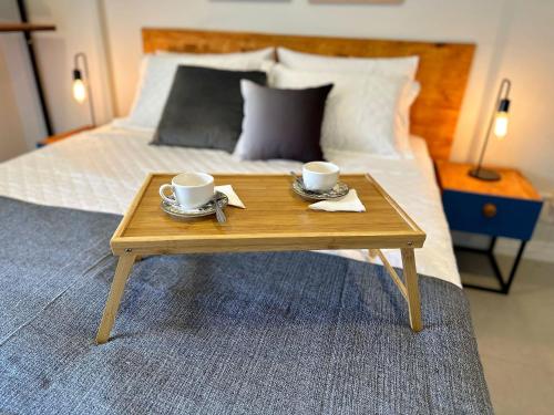 弗洛里亚诺波利斯Home Time Studios的一张木制咖啡桌,床上有2杯