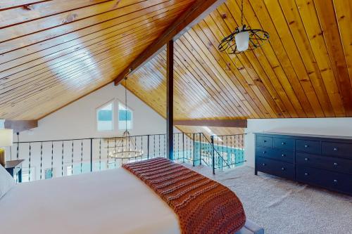 HoodsportAquamarine Dreams的一间卧室设有一张大床和木制天花板