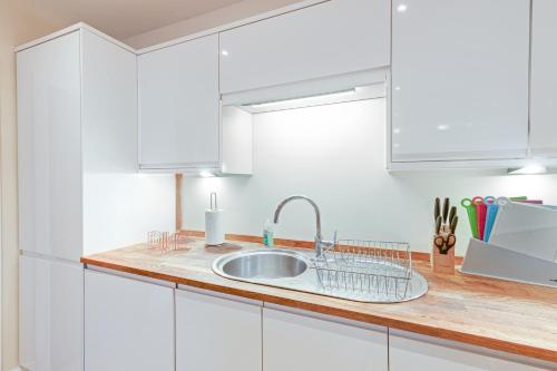 梅登黑德Spacious Luxury 3 Bed Apt W Parking by 360Stays的厨房配有白色橱柜和水槽