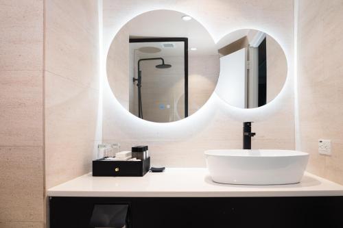 塔穆宁Hotel Tano Guam的一间带水槽和镜子的浴室
