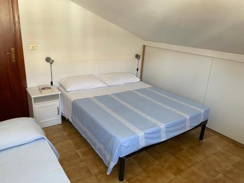 皮内托Una mansarda al mare的一间小卧室,配有床和床头柜