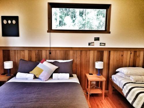 Southport南部森林度假屋的一间卧室设有两张床和窗户。