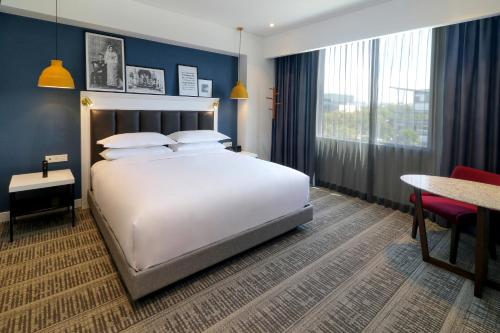 库利亚坎Culiacan Marriott Hotel的卧室配有一张白色的大床和一张桌子