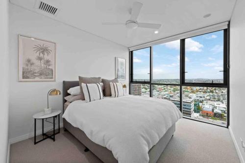 布里斯班New 3 Bed Penthouse Resort style complex的白色卧室设有大床和大窗户