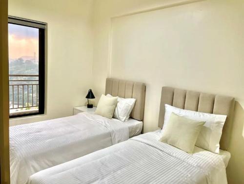 碧瑶One Suite at Bristle Ridge - Baguio City 2BR的白色客房的两张床,设有窗户