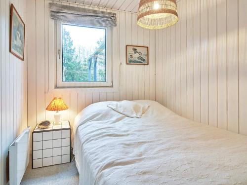 维斯特索马肯Holiday home Aakirkeby XLIV的卧室配有白色的床和窗户。