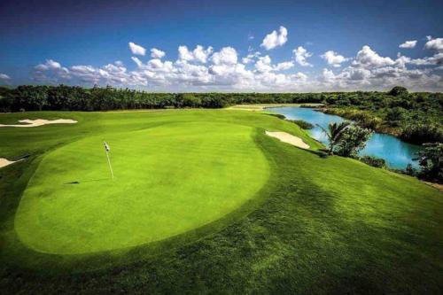 蓬塔卡纳Cana Rock Star luxury condo, Casino, golf, beach in Hard Rock área的享有高尔夫球场和河流的顶部景色